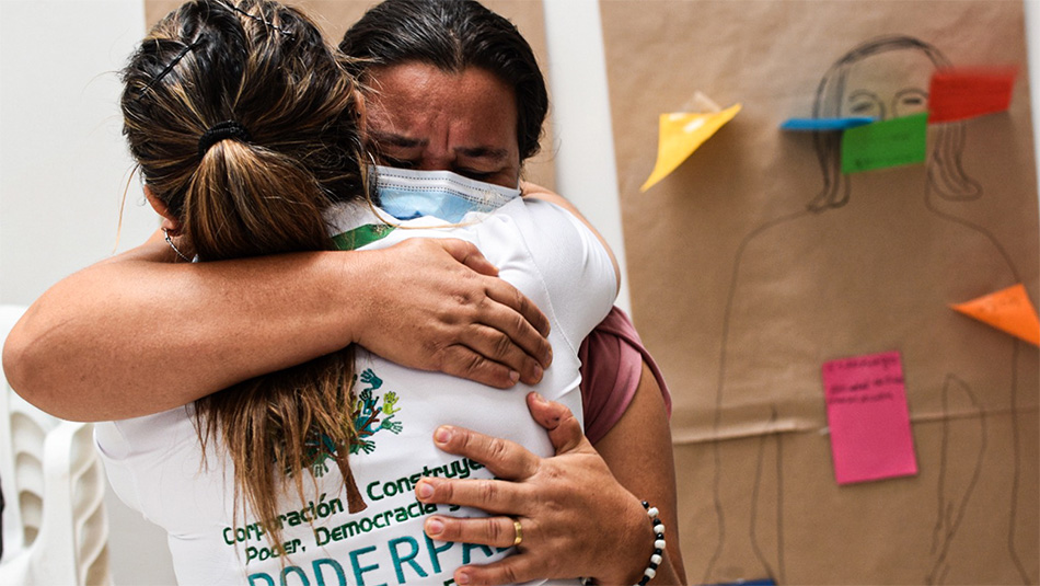 Two women hugging each other during a workshop for the ProPaz II Project in Colombia.